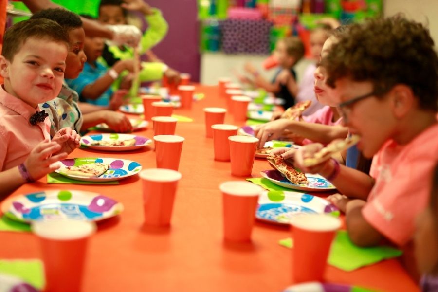 fast food themed party at pump it up with kids sitting at table eating pizza